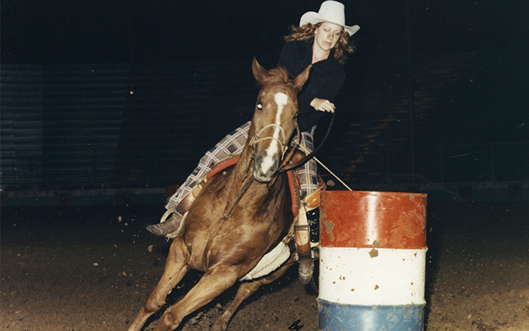 Reba rides horse around barrel